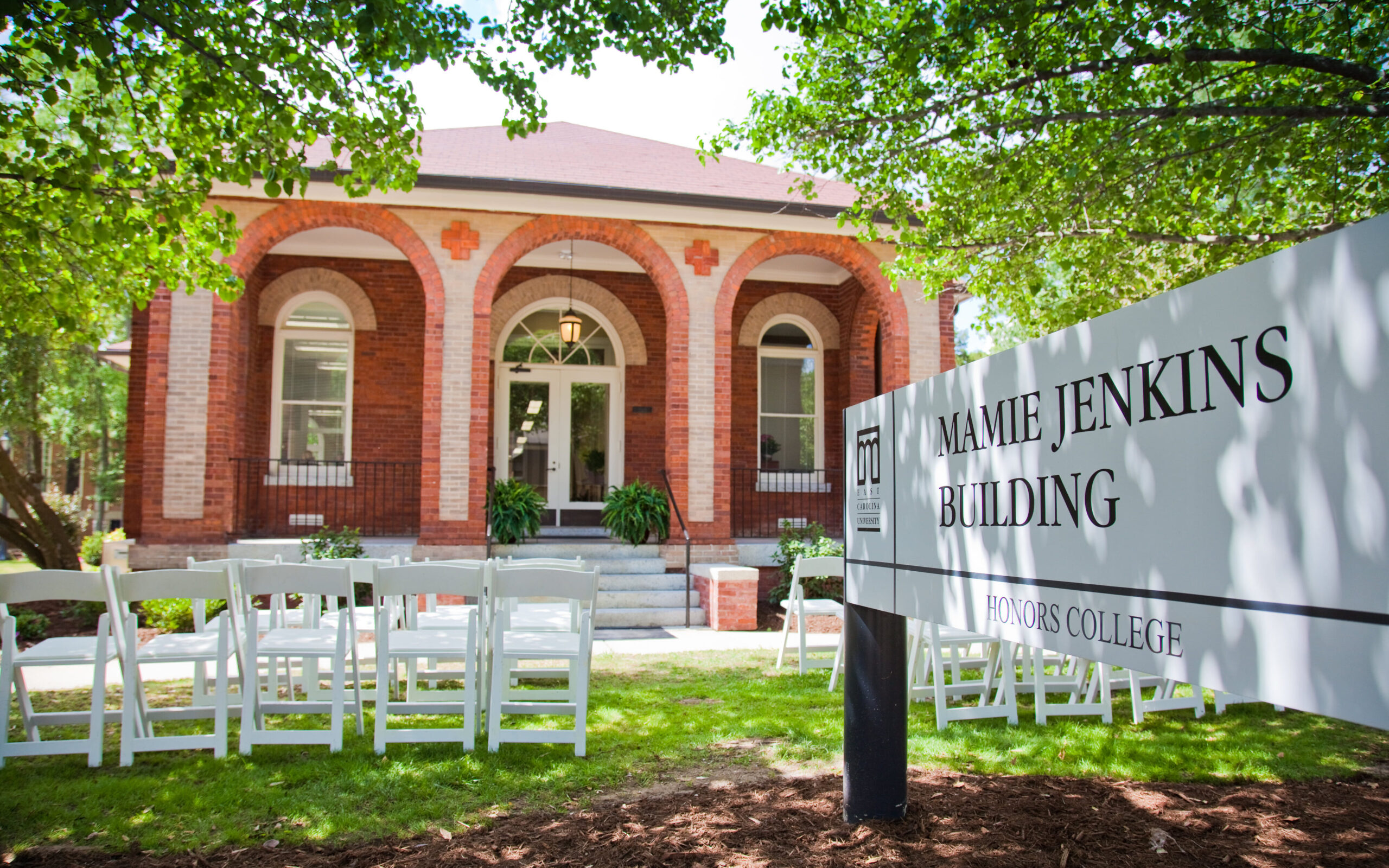 Mamie Jenkins Building, a historic brick building at ECU. The historic building has brick arches surrounding the porch of the building. 